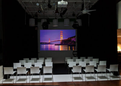 Event setup with tables and a large screen.