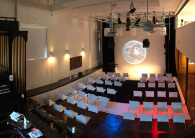 Event layout featuring tables and a projector screen.