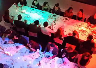 A large group of people dining together at beautifully lit tables.