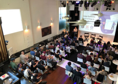 Presentation setup with tables and audience.