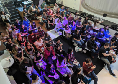 A large audience seated and attentive during a presentation.