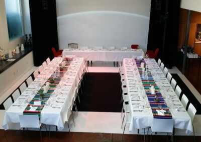 Large tables elegantly set and ready for a dinner event.