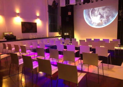 Seating arrangement for a projection screening with decorative lighting.